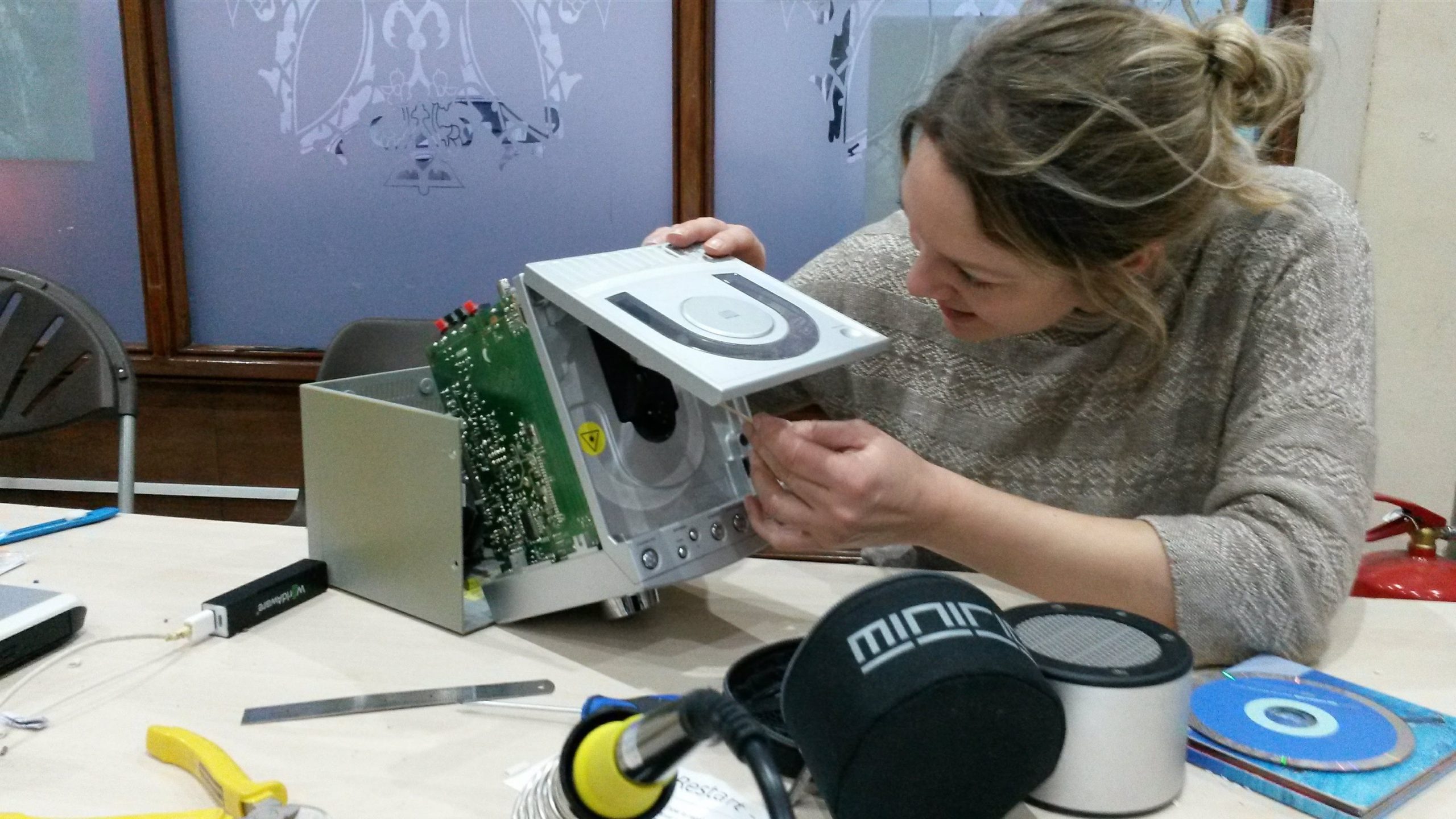 woman repairing a cd player