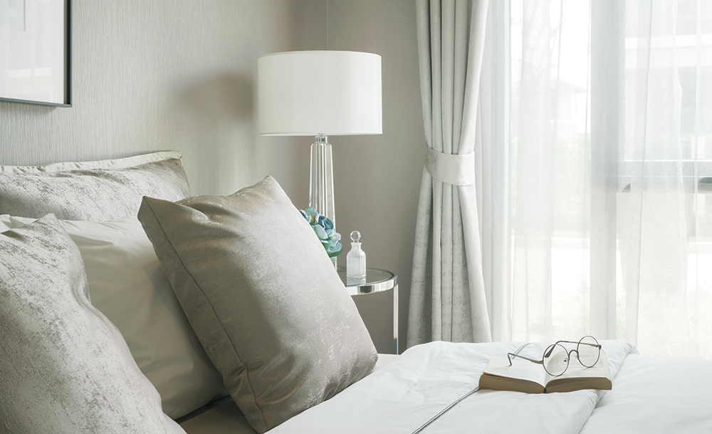 bedroom with reading glasses, book and lamp in very light room