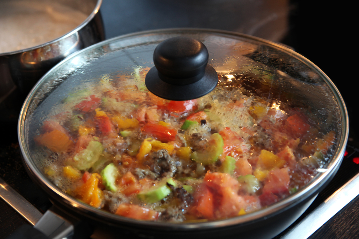 Ratatouille cooking in a covered pan.