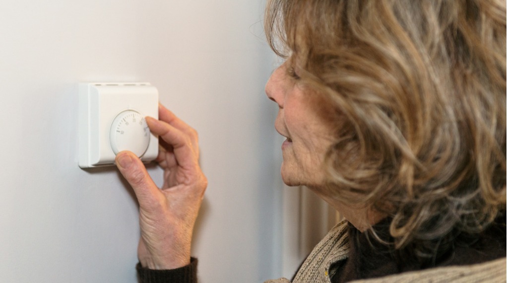 woman adjusting thermostat