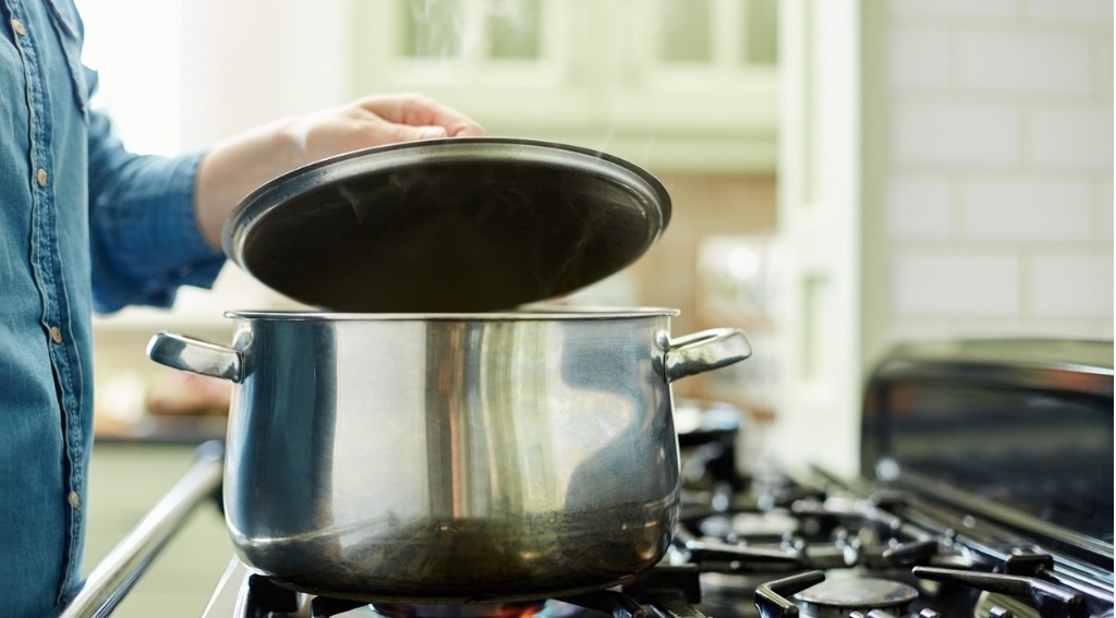 woman putting lid on a pan