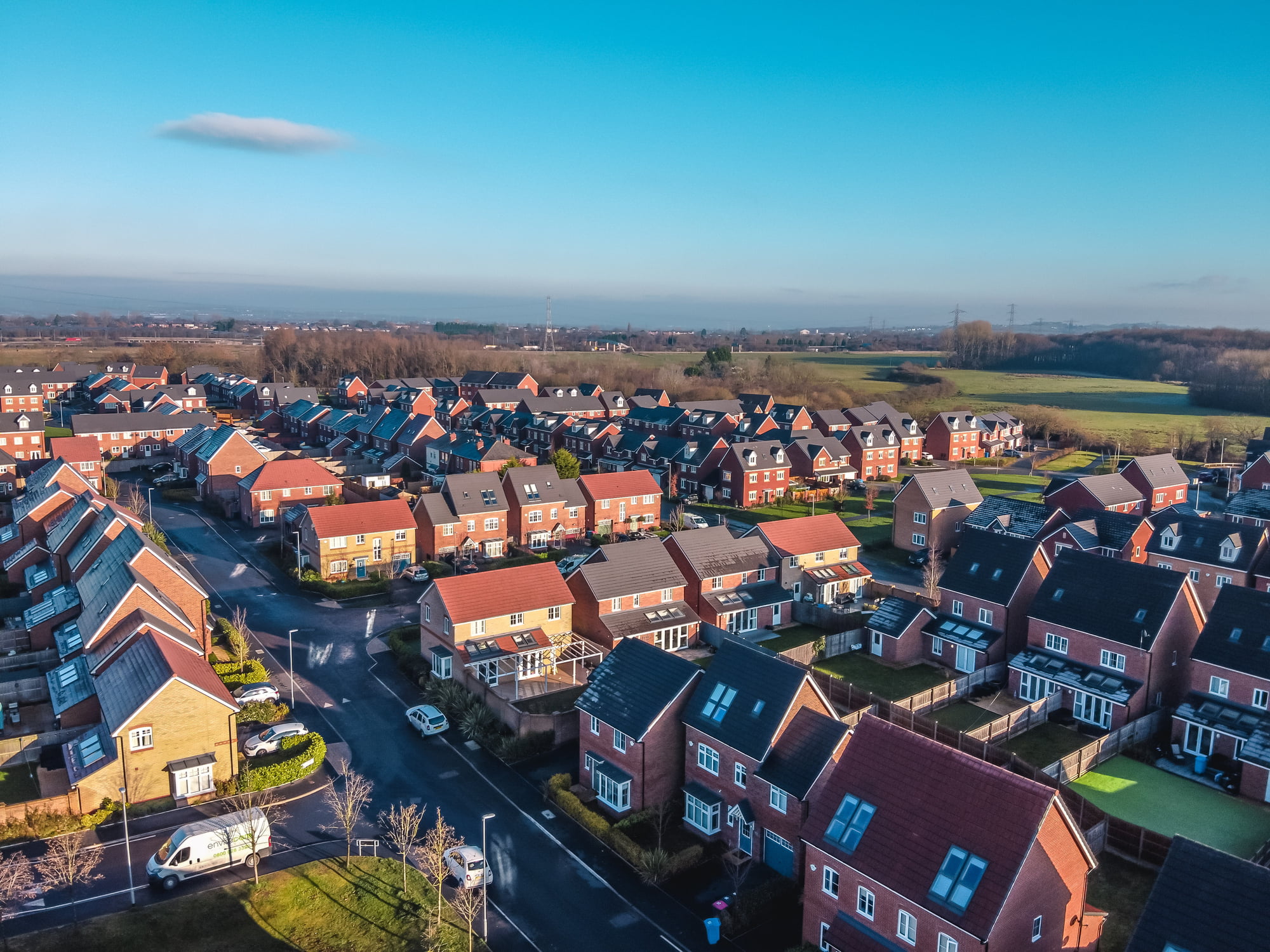 Aerial view of rows of houses under a blue sky