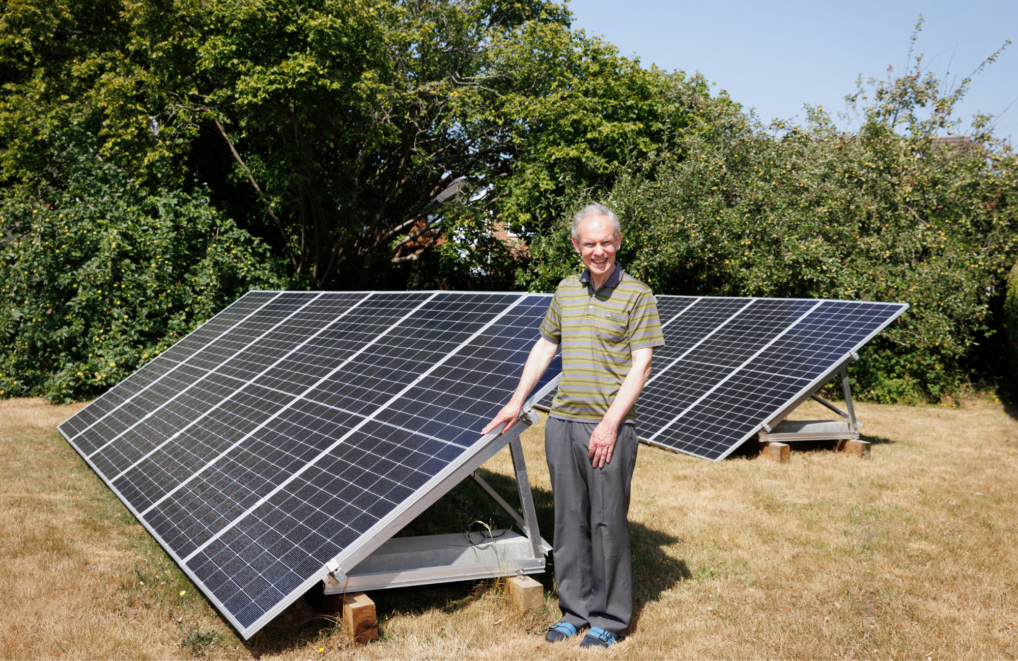 Peter stood outside next to an array of solar panels.