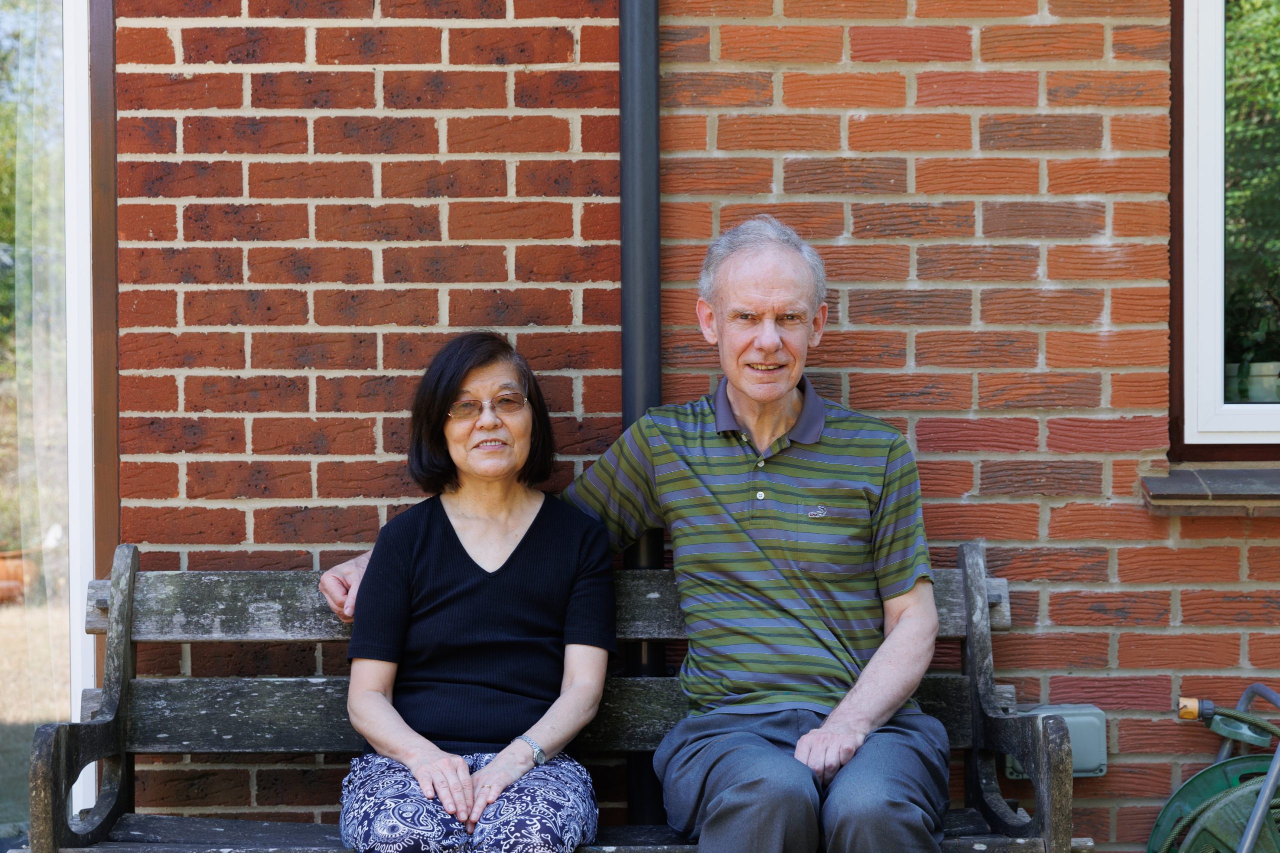 Peter Tuson and his wife, Mei, sat on a bench outside.