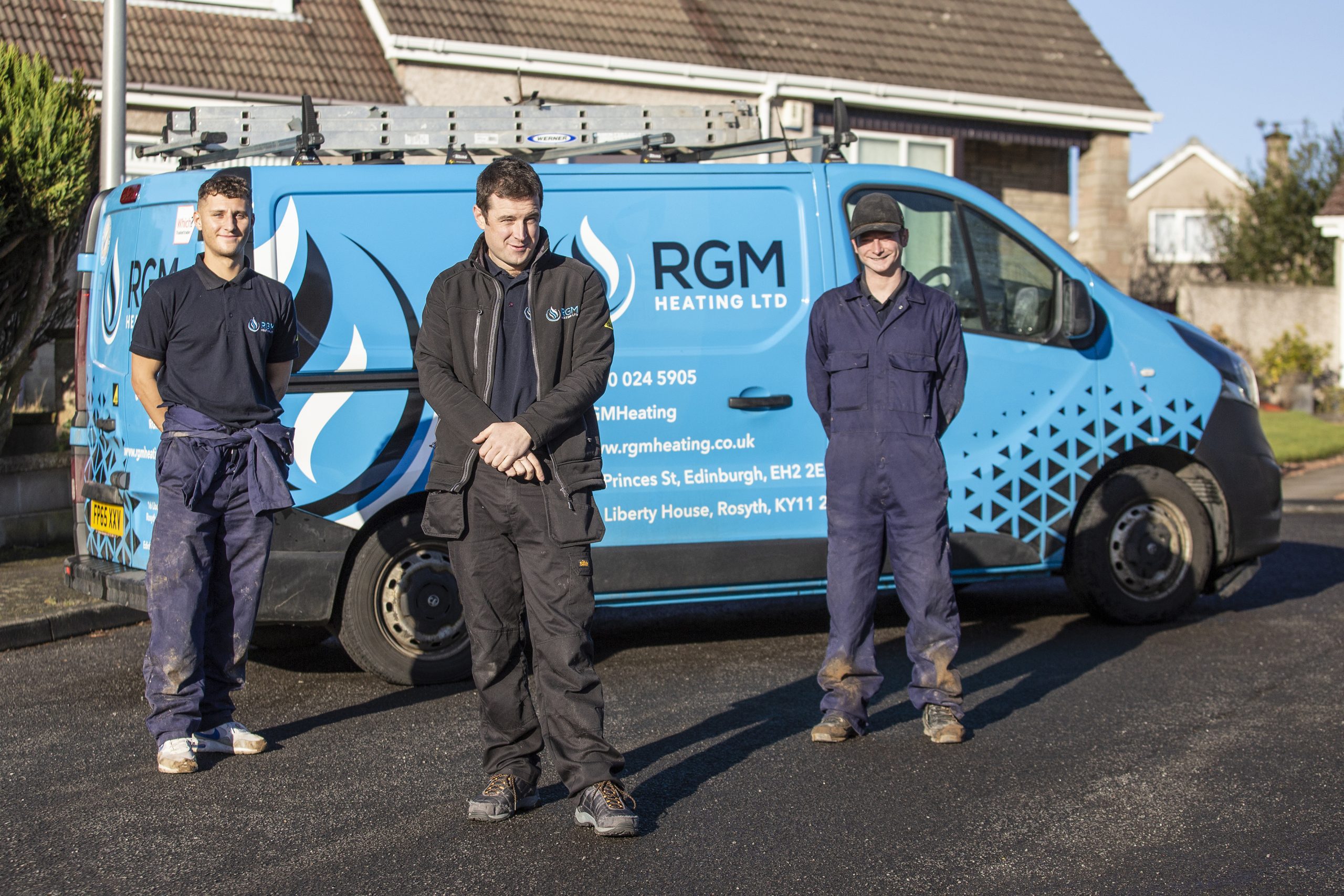 Three installers stand in front of RGM Heating Ltd van