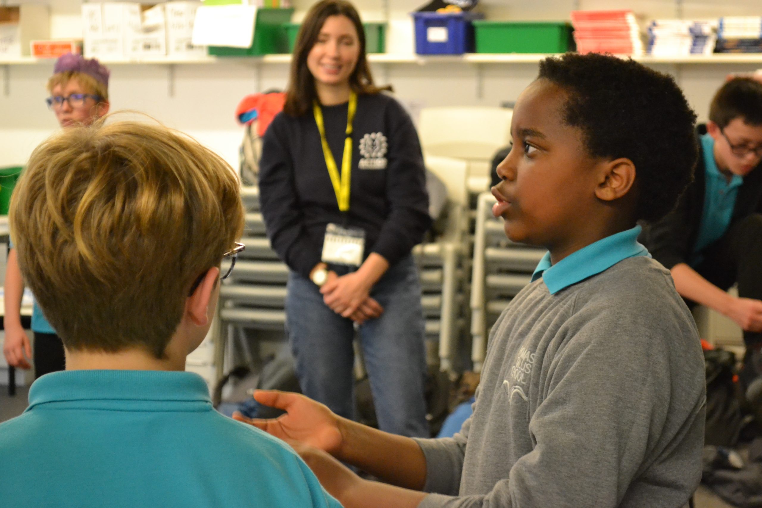 A child speaking to their classmates in a classroom.