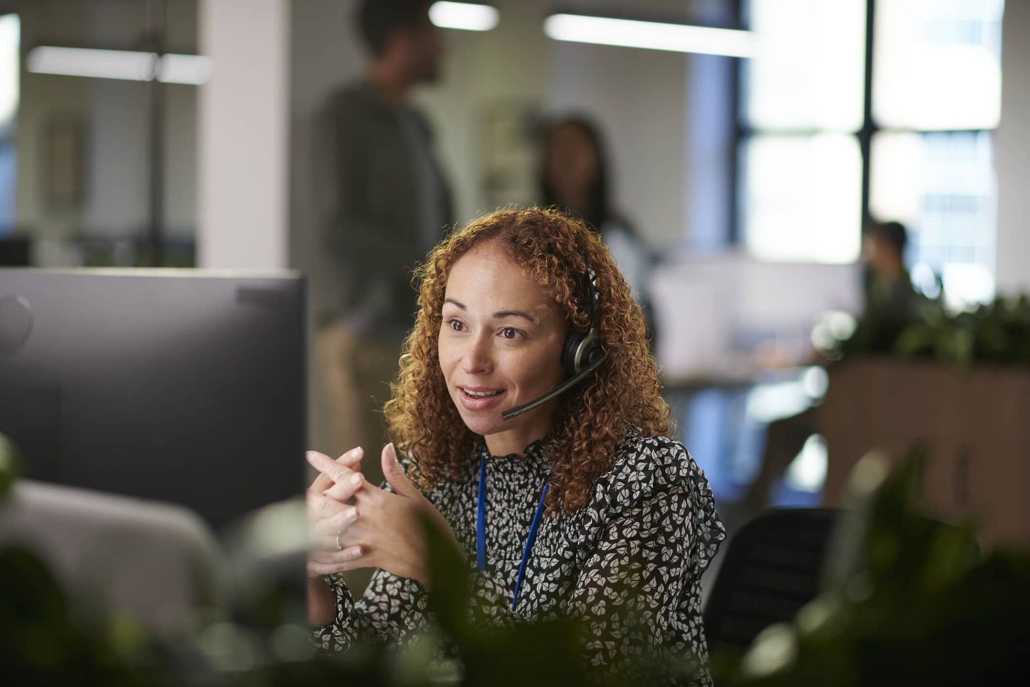 Female worker on a call in a busy office