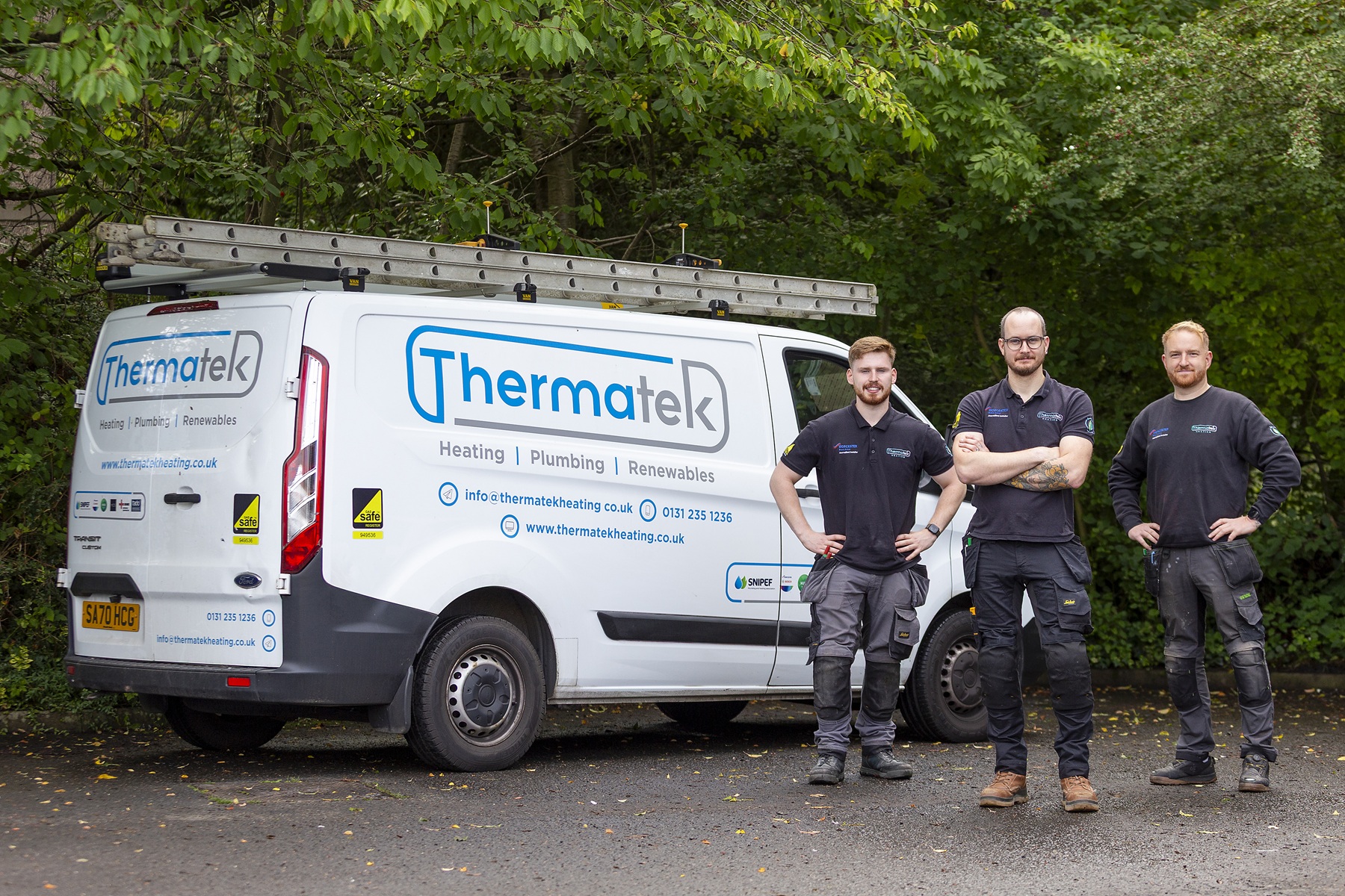 Thermatek installation van parked outdoors with three team members standing beside it.