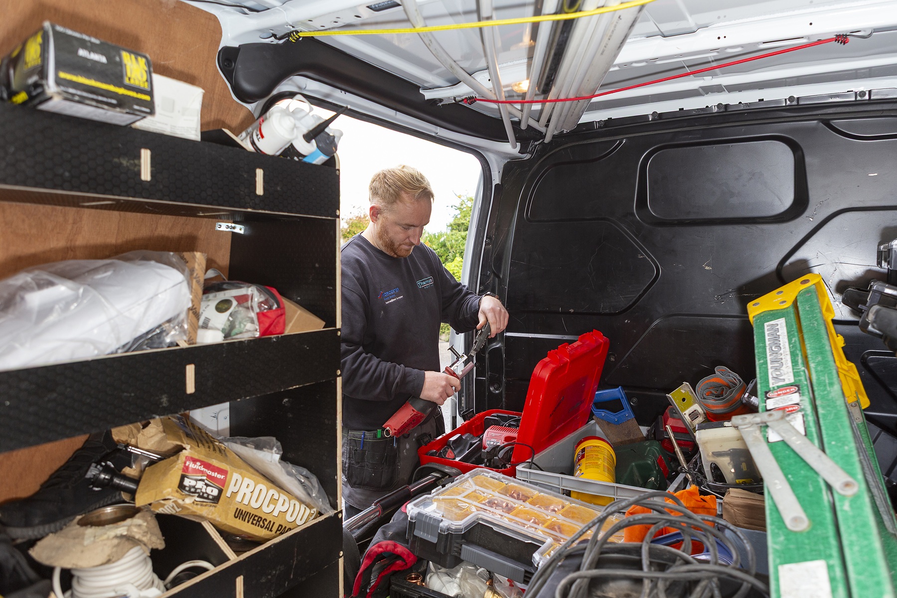 Installer loading equipment into the back of a Thermatek work van.